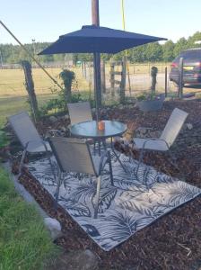 a patio with a table and chairs and an umbrella at Modernised 1720s cottage Newton Stewart Scotland in Newton Stewart