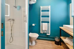 a blue bathroom with a toilet and a shower at Appart'City Classic Blois in Blois