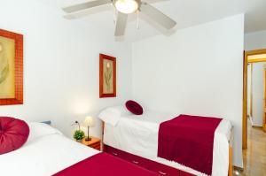 a bedroom with two beds and a ceiling fan at WintowinRentals Pool, Sunny side & Free Parking. in Torre de Benagalbón