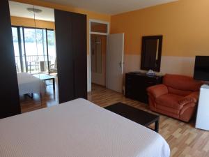 a bedroom with a bed and a living room with a couch at Swiss Lodge Nassa Garni in Lugano