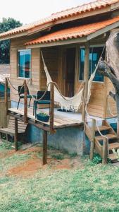 a porch of a house with a hammock on it at Paraíso do Rosa in Praia do Rosa