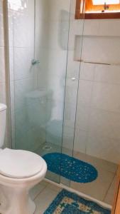a bathroom with a toilet and a glass shower at Paraíso do Rosa in Praia do Rosa +8 photos