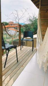 two chairs and a hammock on a porch at Paraíso do Rosa in Praia do Rosa +8 photos