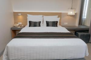 a bedroom with a large white bed with two pillows at Grand Dafam Braga Bandung in Bandung +40 photos