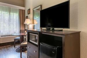 a hotel room with a flat screen tv on a entertainment center at Comfort Inn & Suites DeLand - near University in De Land