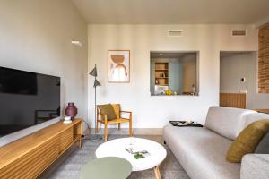 ein Wohnzimmer mit einem Sofa und einem Flachbild-TV in der Unterkunft Aspasios Garden Apartments in Barcelona