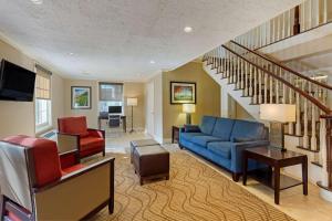 a living room filled with furniture and a staircase at Comfort Inn Rockland - Boston in Rockland