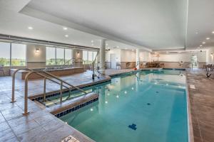 a swimming pool with blue water in a building at Sleep Inn & Suites Lancaster-Platteville in Lancaster