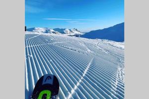 a skier is standing on a snow covered slope at Super sentral, flott og solrik leilighet i sentrum in Hemsedal