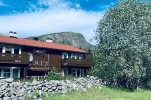 a house with a rock wall next to a mountain at Super sentral, flott og solrik leilighet i sentrum in Hemsedal