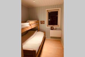 a small room with two bunk beds and a window at Super sentral, flott og solrik leilighet i sentrum in Hemsedal