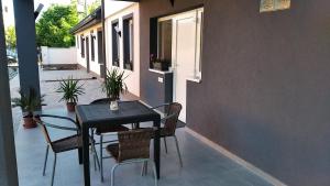 a black table and chairs sitting on a patio at Holdudvar Apartman in Gyula