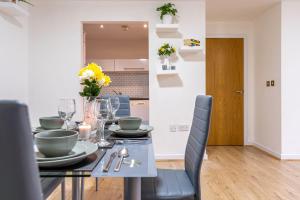 a dining room with a black table and chairs at Riley House Spacious City Apartment in Coventry