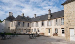 um grande edifício com cadeiras e mesas no pátio em Belle Normandy em Bayeux