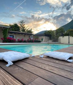 two pillows on a wooden deck next to a swimming pool at CORTE CAIAR Bed&Breakfast in Caprino Veronese