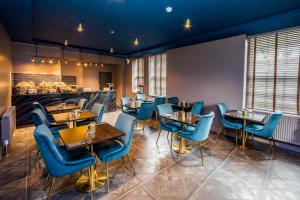 a restaurant with blue chairs and tables and a counter at Stay Hotel in Huddersfield
