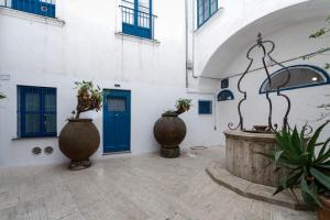 un patio con 2 jarrones grandes y una puerta azul en Qasar Luxury Suite - in Capri's Piazzetta, en Capri