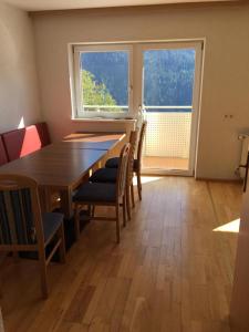ein Esszimmer mit einem Tisch, Stühlen und einem Fenster in der Unterkunft Wohnung 3 Fließ in Fliess