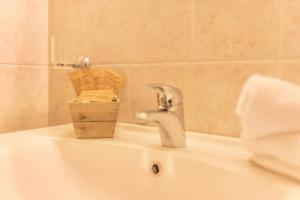 a bathroom sink with a faucet and a wooden box on it at Oberplunerhof - Fewo Kronplatz in Chienes +27 photos