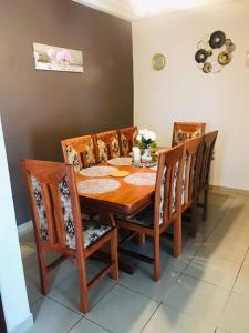 een eettafel met 4 stoelen en een houten tafel bij Appartements meublés Sorel in Douala