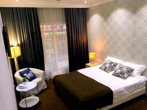 a bedroom with a large bed and a chair at Orynbor Boutique Hotel in Astana