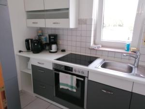 een keuken met een wastafel en een fornuis top oven bij Stollis FeWo in Bensheim