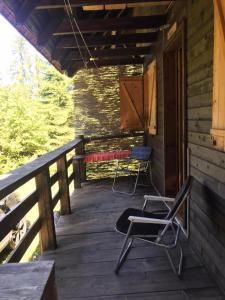 Konjska RekaApartman Mendrea的小屋的门廊配有两把椅子和秋千