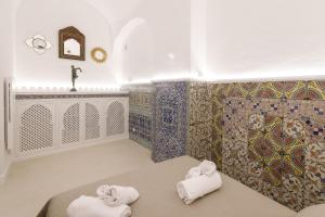 ein Badezimmer mit 2 Handtüchern und einer Mosaikwand in der Unterkunft Qasar Luxury Suite - in Capri's Piazzetta in Capri