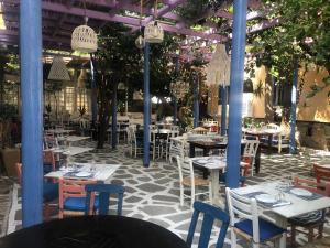 a restaurant with tables and chairs and trees at Big Blue New in Agios Nikolaos