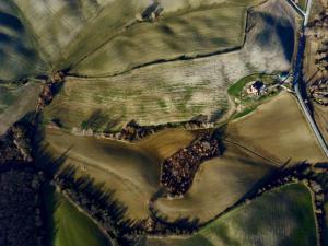 eine Luftansicht eines Feldes mit einem Betrieb in der Unterkunft Vento d’Orcia in Pienza