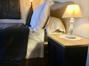 a bedroom with a bed and a table with a lamp at Vento d’Orcia in Pienza