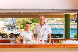 
a man and woman standing in front of a counter at Hotel Guitart Central Park Aqua Resort in Lloret de Mar

