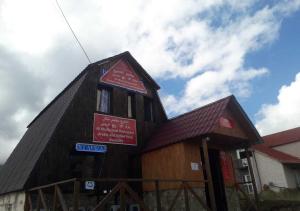 ein großes Holzgebäude mit Schildern darauf in der Unterkunft Taj Hostel in Gudauri