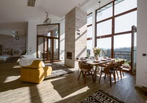 a dining room with a table and a yellow chair at Penthouse Poiana Brașov B44 in Poiana Brasov