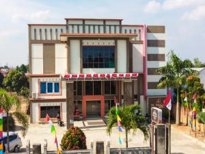 um edifício com bandeiras à sua frente em Collection O 90564 Hotel Merangin Syariah em Bangko