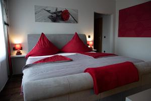 a bedroom with a large bed with red pillows at Restaurant & Pension Rüssel - Pub in Sangerhausen