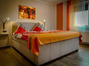 a bed in a room with a painting on the wall at Restaurant & Pension Rüssel - Pub in Sangerhausen