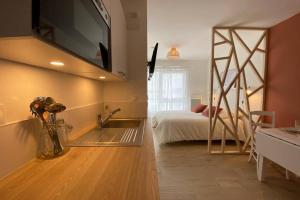 1 dormitorio con 1 cama y TV en la pared en Héol, en Saint-Malo