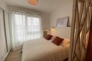 um quarto com uma cama com duas almofadas e uma janela em Héol em Saint Malo