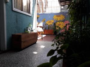 a room with a blue wall with a dresser and plants at Atacama Hostel Backpackers in Santiago