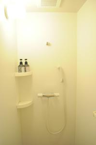 a bathroom with a shower and a toilet and shelves at 04 village Namba - Vacation STAY 17857v in Osaka