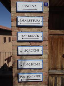 a row of street signs on a brick wall at Residence Le Meridiane in Siena