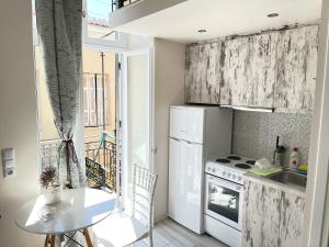 a kitchen with a white refrigerator and a table at Xenias Rooms Apartments in Koroni