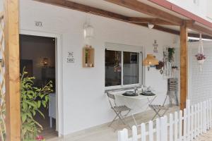 un patio blanco con mesa y sillas. en T0 Junto a Praia de Vale Centeanes / Carvoeiro, en Lagoa