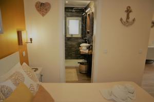 Zimmer mit einem Bett und einem Flur mit einem Spiegel in der Unterkunft T0 Junto a Praia de Vale Centeanes / Carvoeiro in Lagoa