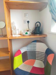 a shelf in a room with a colorful chair underneath it at Sailing's Island Rooms in Inisheer