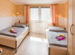 ツィノヴィッツにあるFerienwohnung zur Ostsee 4の花が飾られた部屋のベッド2台