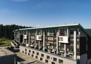 an apartment building with a green roof on top of it at Apartament lux Poiana Brasov B23 in Poiana Brasov