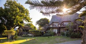 a house with a thatched roof at The Birdhouse Bed & Breakfast #NO Loadshedding #Solar Energy in Gonubie