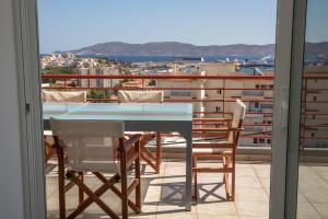 stół i krzesła na balkonie z widokiem w obiekcie 5 Sterne Zeus City Apartment mit Meerblick w mieście Lawrio